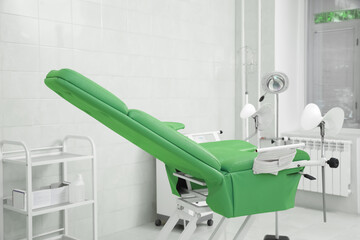 Examination room with gynecological chair and medical equipment in clinic