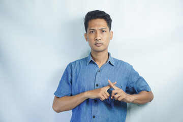 Asian person showing x shape gesture with hands, expressing refusal and disagreement. Young male...