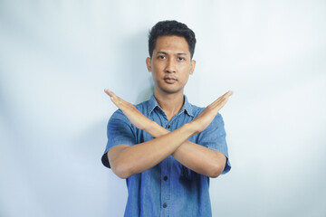Asian person showing x shape gesture with hands, expressing refusal and disagreement. Young male...