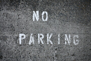 no parking painted on concrete, white letters