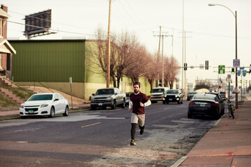 Young man jogging on the street of a suburb