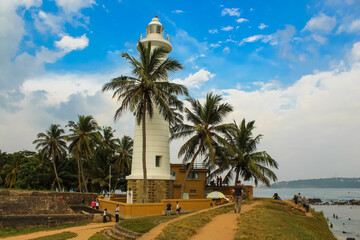 Lighthouse in Galle fort, Sri Lanka. Indian ocean shore, palms, Sri Lanka.