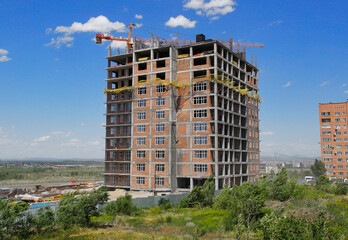 Building under construction. Residential building. Urban grunge. New residential area. Construction site. Construction crane. Blue sky. Summer time. Ust-Kamenogorsk (kazakhstan)