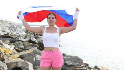National flag of Russia. Beautiful woman with Russia flag on the beach. High quality 4k footage - Powered by Adobe