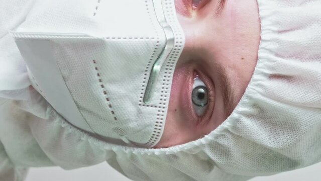 Vertical video. Environment scientist. Infection disaster. Female woman ecology specialist taking off protective medical equipment goggles mask gloves.