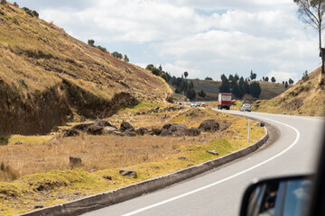 Carretera en las montañas de los andes asfaltada con carros en ambos lados de la vía en ecuador...