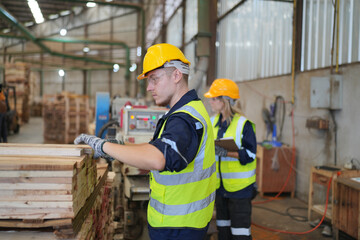 Worker are working at lumber yard in Large Warehouse. Worker are  working.on woodworking machine, lumber and Inventory check at Storage shelves in lumberyard.