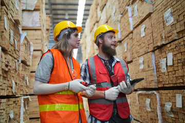 Worker in a timber and lumber warehouse. Product acceptance and quality control. worker doing...