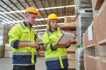 Woman with checklist in a timber and lumber warehouse. Product acceptance and quality control