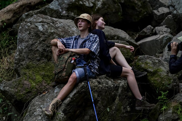 Smiling young people enjoying hiking at nature and talking outdoor. young people Hiking On Mountain And Enjoys Nature.