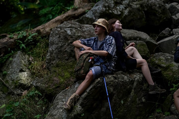 Smiling young people enjoying hiking at nature and talking outdoor. young people Hiking On Mountain And Enjoys Nature.