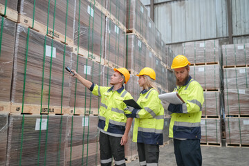 Warehouse workers checking inventory in a large distrubiton warehouse.