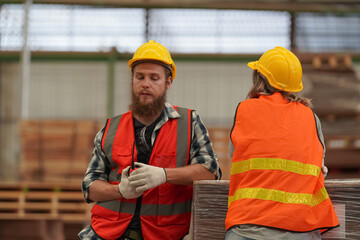 Warehouse worker working at lumber yard in Large Warehouse. Worker are  Inventory check at Storage...