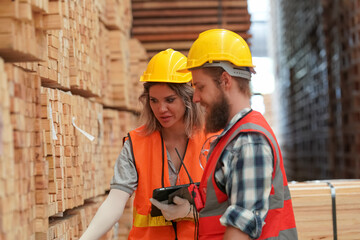 Warehouse worker working at lumber yard in Large Warehouse. Worker are  Inventory check at Storage...