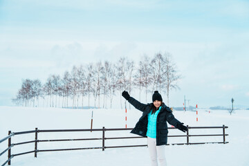 Woman tourist Visiting in Biei, Traveler in Sweater sightseeing view with Snow in winter season....