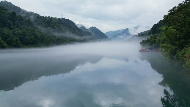 An early morning drone shot on a low lever along the beautiful river surrounded by majestic mountains