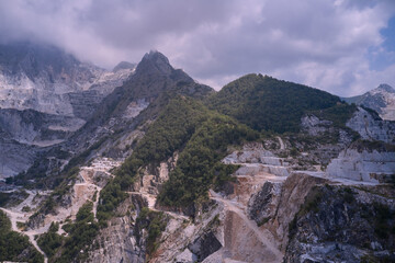Marble quarry top view. Aerial panorama on the Carrara marble quarry. Industrial machinery in a quarry.