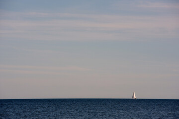 Fototapeta premium A sailboat heading out to sea on a beautiful summer day