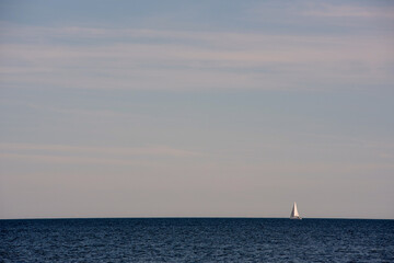 A sailboat heading out to sea on a beautiful summer day