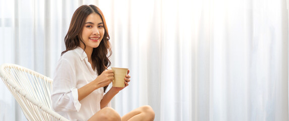 Portrait of smiling happy cheerful beauty pretty asian woman relaxing drinking and looking at cup...