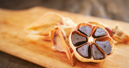 Black garlic on old wooden board
