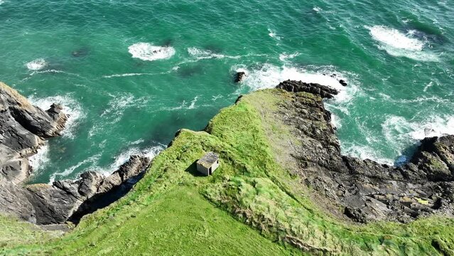 Coast of Ireland drone old WW2 building high on a sea cliff at Copper Coast Waterford on a blustery summer day