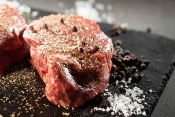 Season raw meat with salt and pepper for steak.