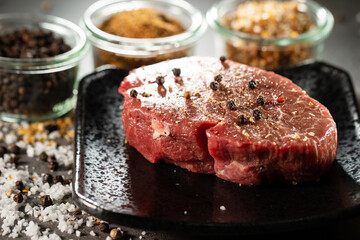 seasoned raw meat with salt and pepper for steak.	