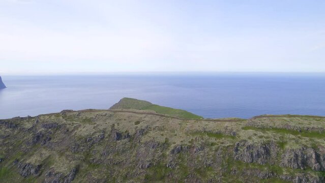 Drone Flying over a ridge with a hiking trail to reveal a arctic landscape and cliffs.--Hornstrandir, Westfjordss, Iceland
