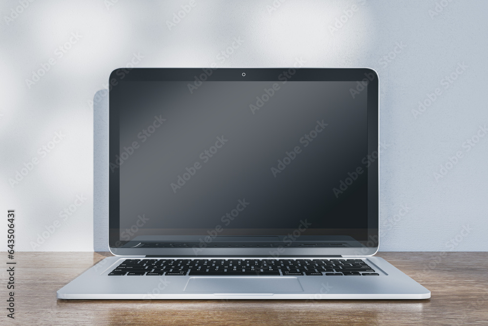 Poster Close up of laptop with empty mock up screen placed on wooden desk. Concrete wall with shadows in the background. 3D Rendering.