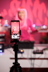 Asian female having fun while recording video with her performing techno music at professional...