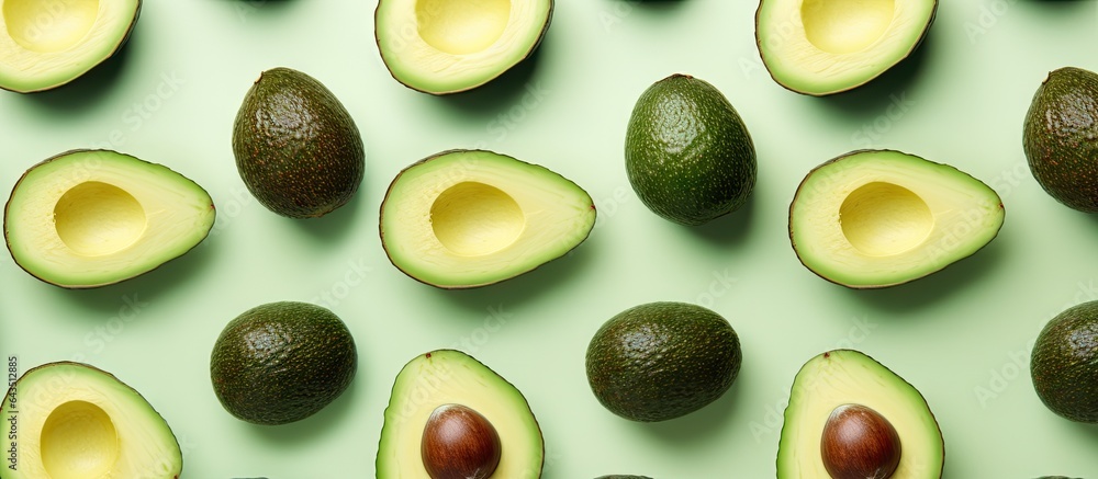 Poster avocado halves arranged in a pattern on a vibrant mint green background