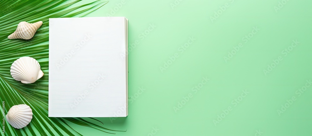 Poster seashell themed notebook for summer holiday green background top view flat lay concept