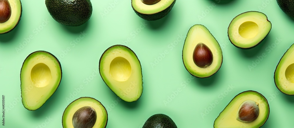 Aufkleber avocado halves arranged in a pattern on a vibrant mint green background
