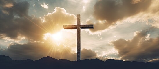 Digital composite of a wooden cross with cloudy sunset sky representing Ascension day and Christian beliefs