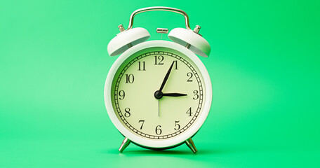 Alarm clock on green background.