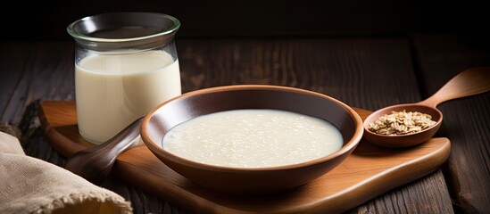 A healthy bowl of porridge sugar milk spoon on a wooden board wooden background copy space