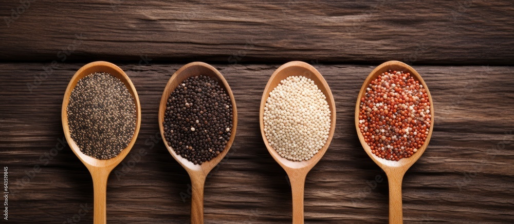 Poster top down view of white red and black quinoa seeds on wooden background with room for text
