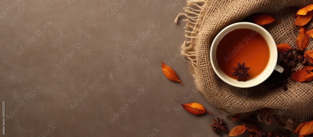 Poster flat lay composition in autumn or winter with a coffee cup dry leaves and dried orange on a linen fa