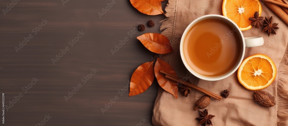 Poster flat lay composition in autumn or winter with a coffee cup dry leaves and dried orange on a linen fa