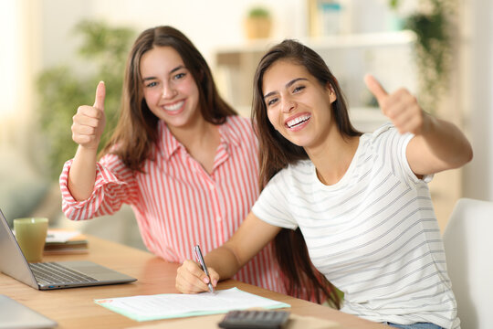 Happy roommates signing form with thumbs up