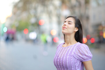 Woman breathing fresh air in a wide street