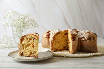 Delicious Italian Easter dove cake (traditional Colomba di Pasqua) on white wooden table, space for...
