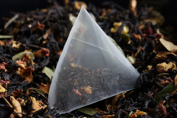 A triangular tea bag pyramid with black flavored tea, with the addition of berries, fruits and...