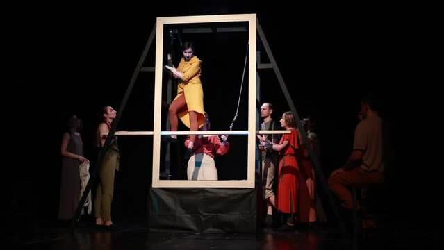 Actors and actresses perform a modern performance on the stage of the theater.	