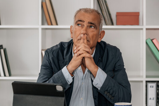 thoughtful middle aged business man in office - Powered by Adobe