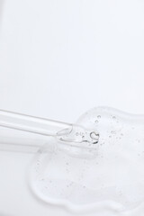 Dripping cosmetic oil from pipette onto light surface, closeup. Space for text
