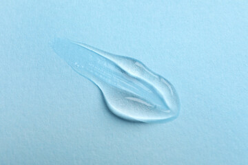 Swatch of cosmetic gel on light blue background, top view