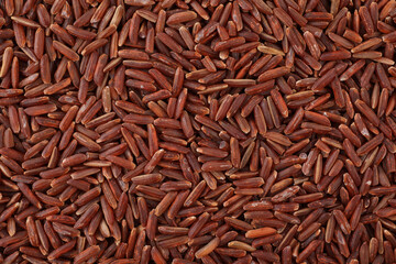 Raw red rice as background, top view