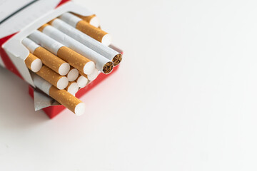 Pack of cigarettes on a photo of hundred-dollar notes. Concept of high cost of smoking